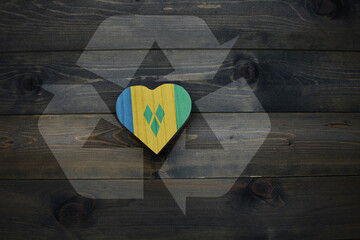 wooden heart with national flag of saint vincent and the grenadines near reduce, reuse and recycle...