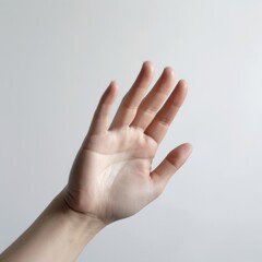 A human hand is raised against a plain background