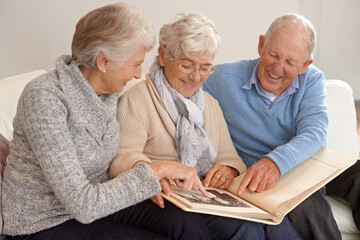 Elderly people, group and together with photo album, living room and pictures with memories, lounge...