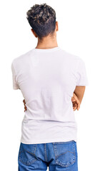 Young handsome man wearing casual white tshirt standing backwards looking away with crossed arms