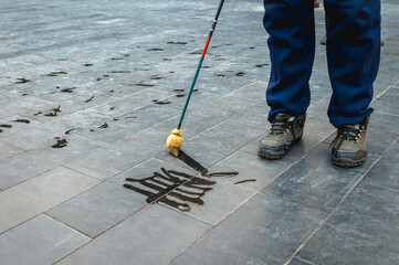 Man practising chinese calligraphy near the Temple of Heaven in Beijing, China