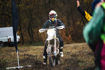 Professional enduro motorcycle rider in sport gear starts, a person participates  in motocross...