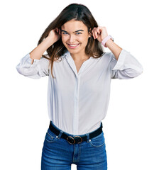 Young caucasian girl wearing casual white shirt smiling pulling ears with fingers, funny gesture....