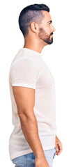 Young hispanic man wearing casual clothes looking to side, relax profile pose with natural face with confident smile.