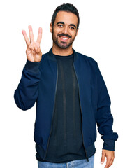 Young hispanic man wearing casual clothes showing and pointing up with fingers number three while smiling confident and happy.