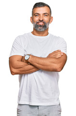 Middle age handsome man wearing casual white tshirt happy face smiling with crossed arms looking at the camera. positive person.