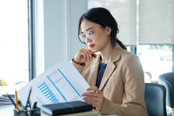 Businesswoman working on analyzing charts and graphs.