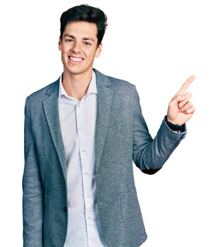 Young hispanic man wearing business clothes with a big smile on face, pointing with hand finger to the side looking at the camera.