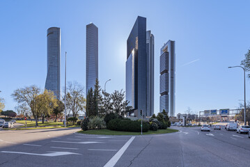 Fototapeta na wymiar An urban traffic distribution roundabout next to office skyscrapers in the northern area of Madrid that is called four towers, but in reality there are five