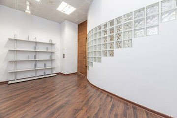 An empty office with curved walls with glass paving bricks