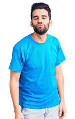 Young handsome man with beard wearing casual t-shirt looking at the camera blowing a kiss on air being lovely and sexy. love expression.
