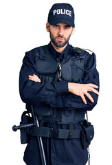Young handsome man with beard wearing police uniform skeptic and nervous, disapproving expression...