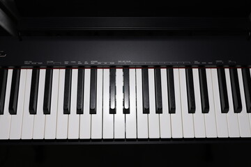 Glare on the black keys of a digital piano. Pianist's musical instrument. Ivory piano keys.