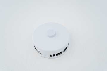 White smoke detector on white surface in automotive lighting