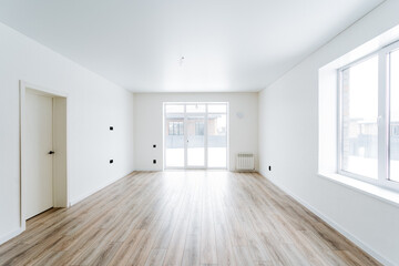 Empty living room with hardwood floors and white walls