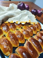 Close-up of rosy, baked pies on a wooden surface