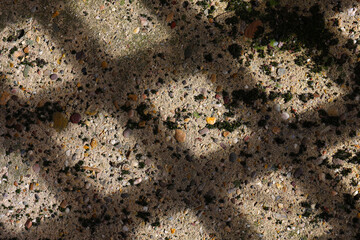 A shadow pattern from garden fence on a concrete floor