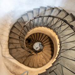 Fototapeta premium A captivating view of a descending spiral staircase, showcasing the architectural beauty and design, captured from the top angle