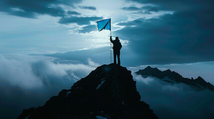 A man standing on top of a mountain holding up a blue flag with his hand - obrazy, fototapety, plakaty