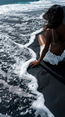 Woman in waves on black sand beach - obrazy, fototapety, plakaty