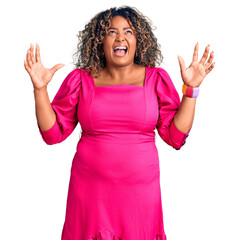 Young african american plus size woman wearing casual clothes crazy and mad shouting and yelling...