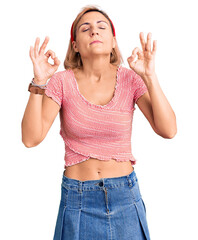 Young blonde woman wearing casual clothes and diadem relax and smiling with eyes closed doing meditation gesture with fingers. yoga concept.