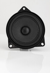 Small loudspeaker for mounting on automotive doors on white reflective surface.