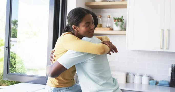 African American couple shares a warm embrace, hugging in the kitchen