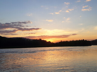 Sunset over the forest river. Beautiful sunset over river. River at sunset. Sunset river water