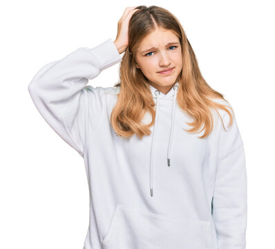 Beautiful young caucasian girl wearing casual sweatshirt confuse and wonder about question. uncertain with doubt, thinking with hand on head. pensive concept.