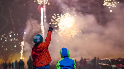 Two kids enjoy the night fireworks - Powered by Adobe