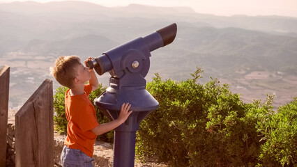 Kid on telescope viewpoint of El Toro Mountain in Menorca, Balearic Islands Spain