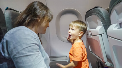 Mother and child talking in the airplane during long flight