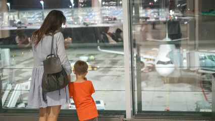 Mother and son watch the airplane in the airport