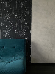 Part of the interior, an aquamarine sofa on a wall background and black and white wallpaper