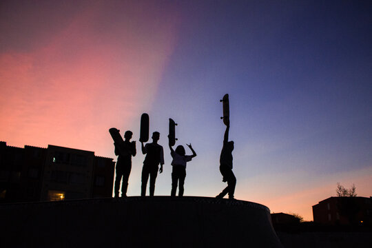 people at sunset with skateboards