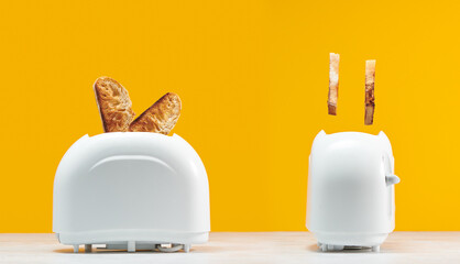 Roasted toast bread popping up of toaster with yellow wall