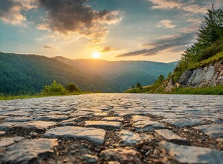 Low level view of empty old paved road in mountain area at sunset