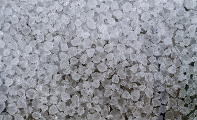 a lot of round crystals of ice precipitation fell in the form of hail after a thunderstorm in spring