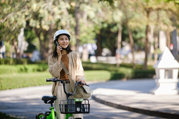Beautiful woman taking a bike stroll in the park, business woman holding smartphone using bike rental, business woman holding smartphone using bike rental digital phone.