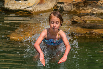 Funny portrait of young beautiful girl getting ready to jump for a swim.