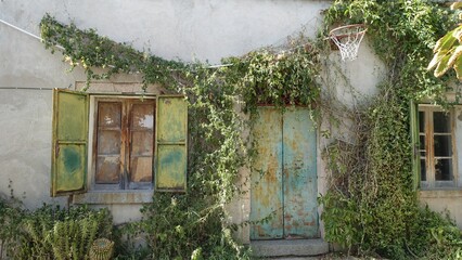 The facade of an old abandoned country house with an old basketball hoop on the wall