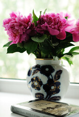 peonies in a vase on the window