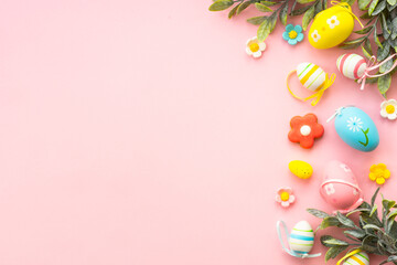 Easter background. Eggs, spring leaves and flowers on pink. Flat lay with copy space.