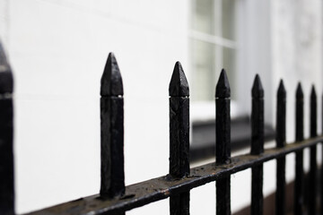 black spiked railings or gate against white formal building 