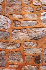 Clos-up of stone wall with orange cement 