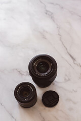 a pair of camera lenss are sitting on a marble counter