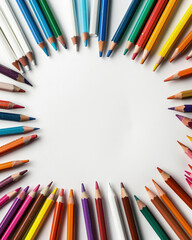 A blank white page surrounded by crayons and pencils, in a flat lay, top view. School supplies with copy space.