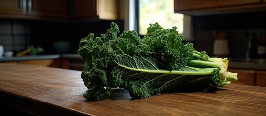 A selection of green vegetables, including kale, are neatly arranged on a wooden counter. The vibrant colors and textures of the fresh produce add a pop of natural beauty to the rustic setting.