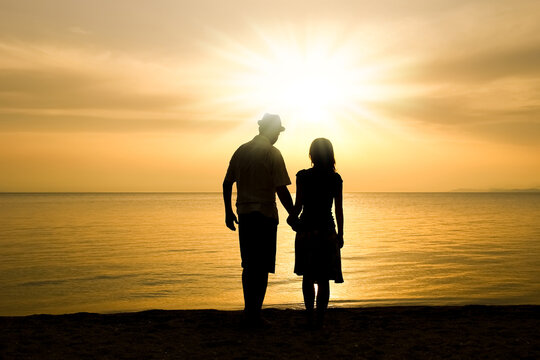 A happy couple by the sea on nature in travel silhouette